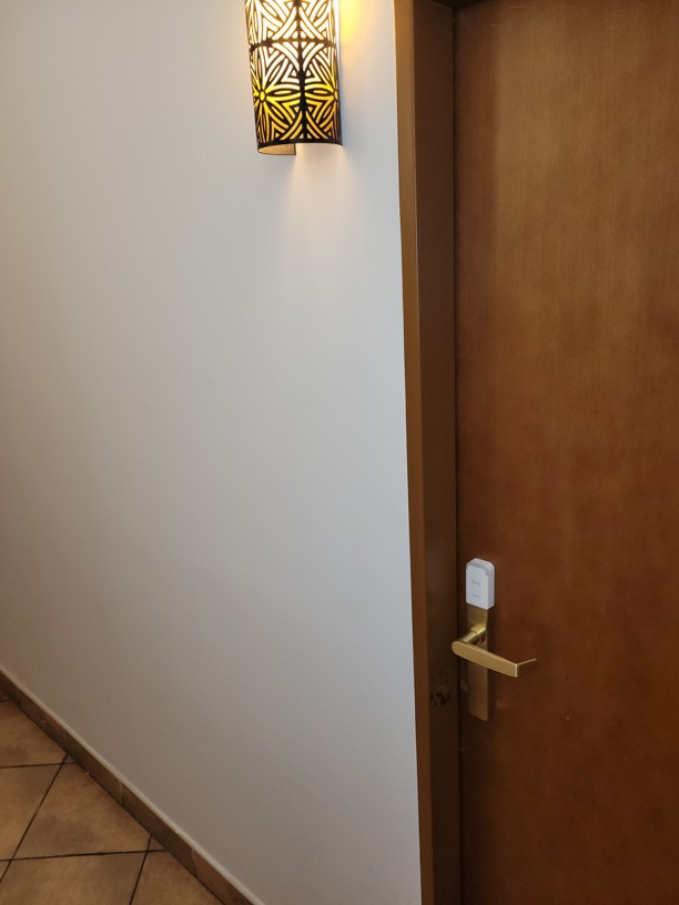 Detail elegantního chytrého kování Salto SPACE na dveřích hotelového pokoje, které umožňuje hostům otevírání pomocí mobilního telefonu.