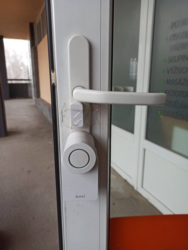 Původní nevyhovující řešení vstupu do fitness centra s bateriovou motorickou vložkou na běžném zámku.