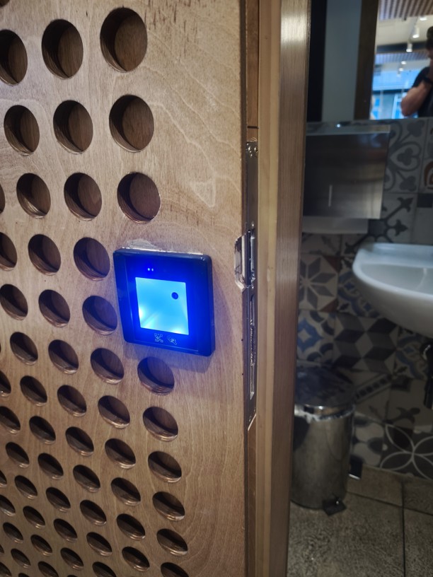 Čtečka QR kódu instalovaná u dveří na toaletu