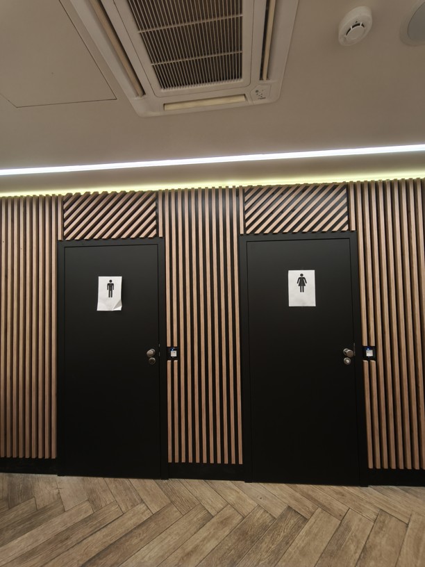 Pohled na dvojici dveří na wc v restauaci, dveře jsou opatřeny čtečkou qr kódu