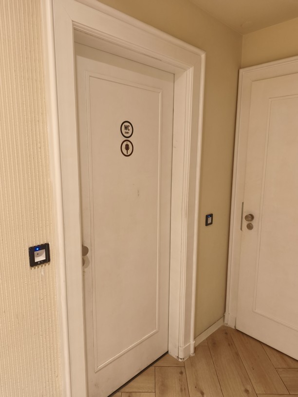 Bílé decentní dveře opatřené nástěnnou čtečkou qr kódu