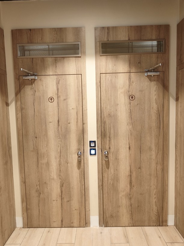 Dvojice moderních designových dveříí na wc, které jsou opatřené čtečkou QR kódu