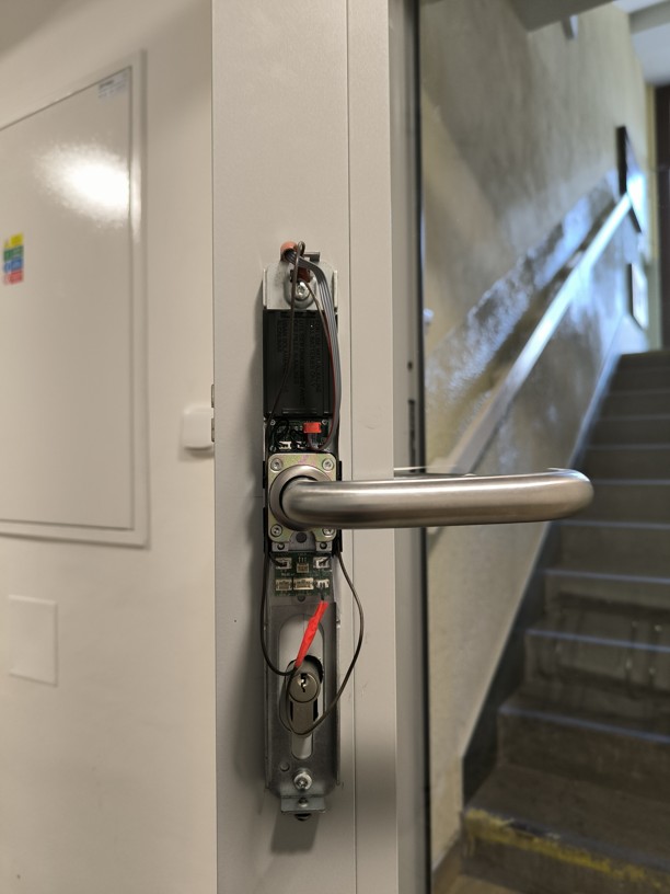 Odborná instalace a zapojování elektroniky vnitřní části kování SALTO XS4ONE na profilových hliníkových dveřích.