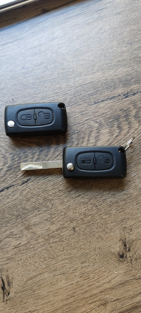 Detail nového obalu autoklíče Citroen Berlingo vedle klíče s čipem po odborné výměně.