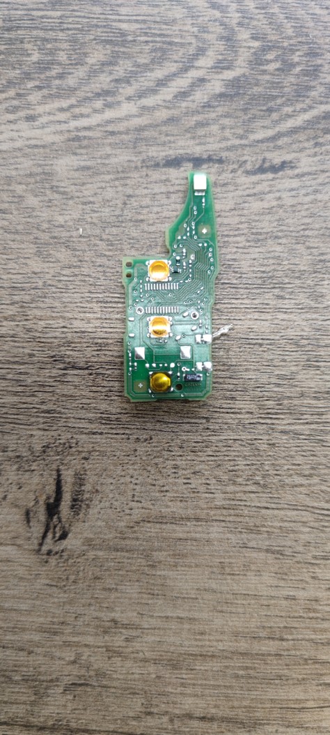Detailní pohled na elektroniku a mikrospínače dálkového ovládání autoklíče VW Tiguan před opravou.