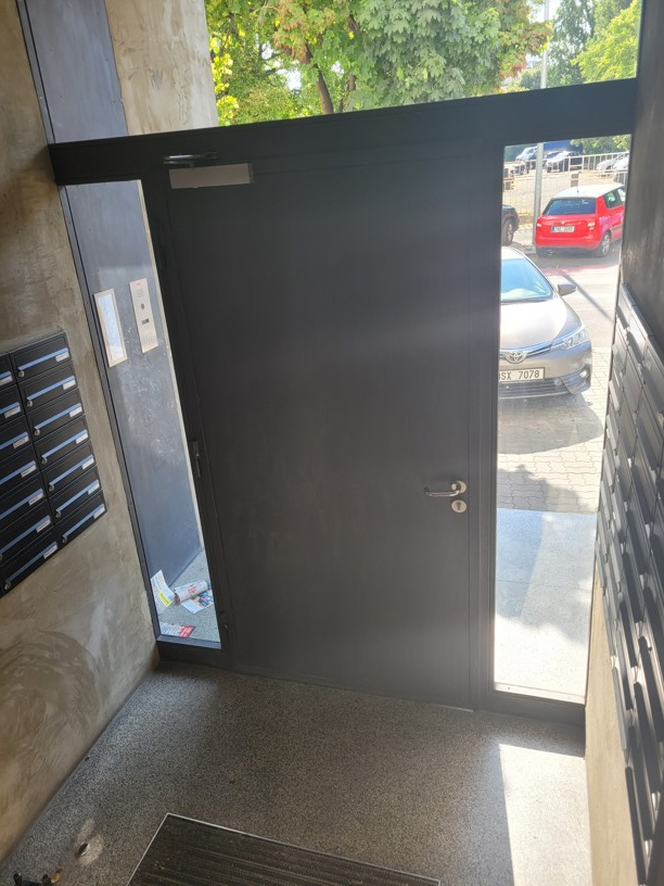 Těžké dveře do bytového domu určené pro pohon dveří