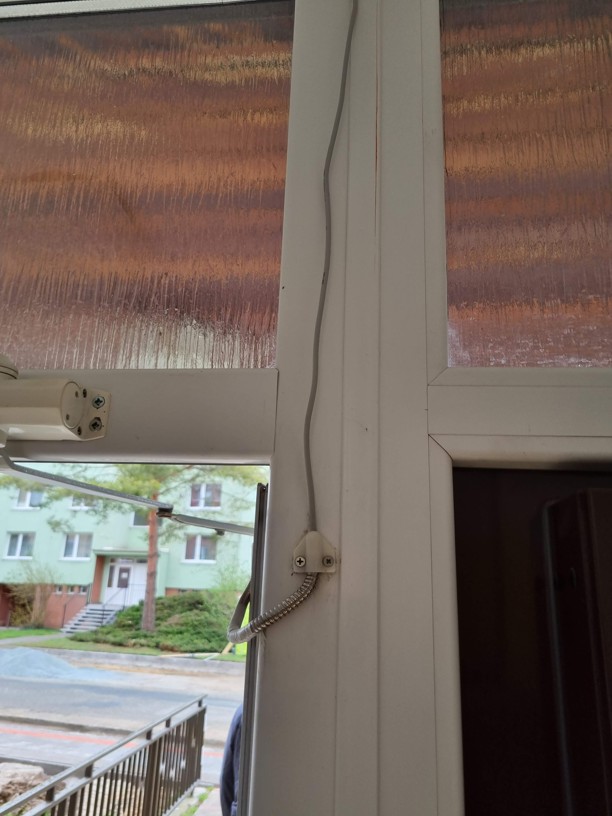 Kabel tažený po dveřním křídle