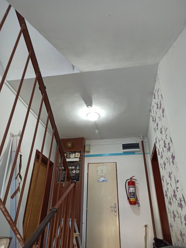 Nové úsporné stropní svítidlo s integrovaným pohybovým senzorem a nové vedení kabeláže v elektroinstalační liště na chodbě bytového domu.