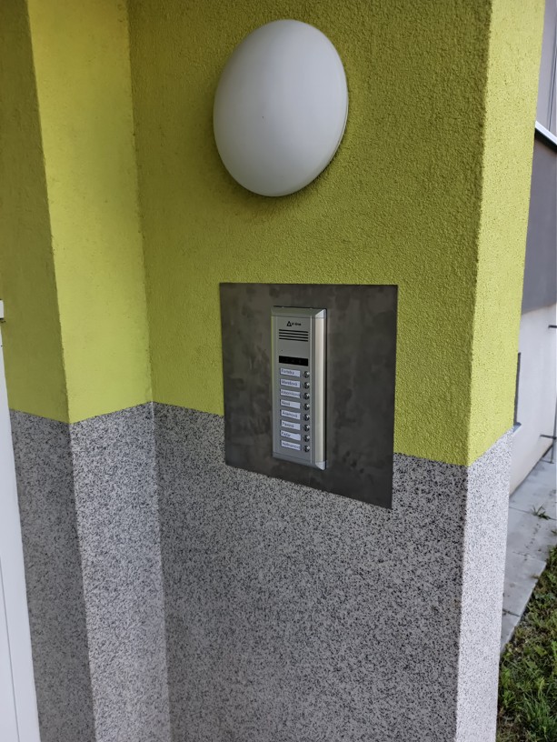 Nové venkovní tablo digitálního domovního telefonu s 8 tlačítky instalované u vstupu do bytového domu v Jičíně.