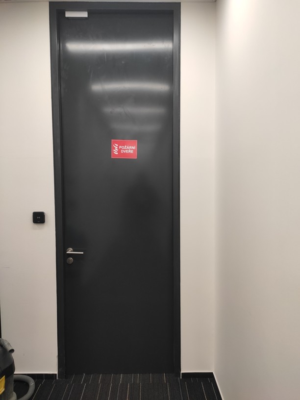 Detail instalovaného dveřního přídržného elektromagnetu s přídržnou silou 300 kg na ocelové zárubni v Praze.