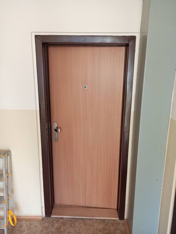 Původní staré vchodové dveře v panelovém domě před plánovanou kompletní výměnou za bezpečnostní.