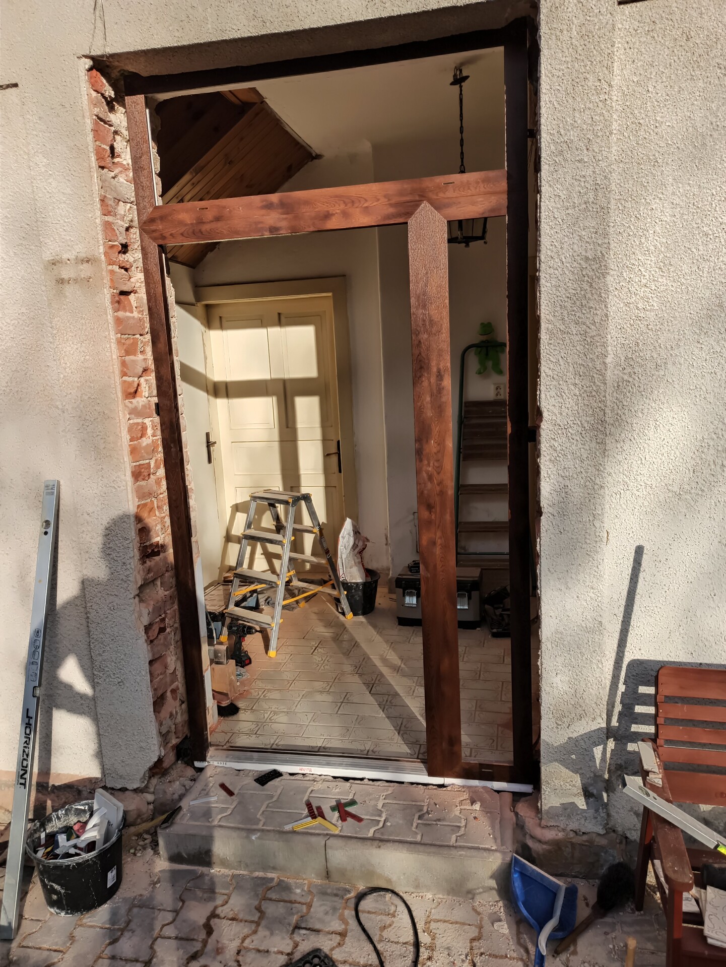 Přesné usazování a kotvení masivní zárubně pro hliníkové dveře GERDA s bočním světlíkem.