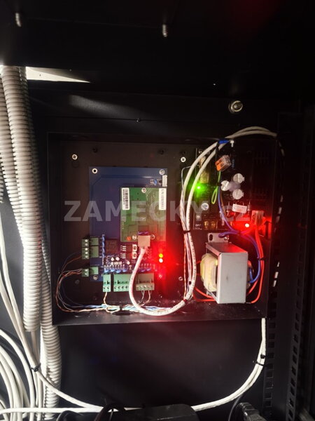 Otevřený instalační rozvaděč s profesionálně zapojenou řídící jednotkou Al2S přístupového systému ACS. Fotografie ukazuje spolehlivou řídící desku a integrovaný záložní zdroj s napojením na 230V, což zaručuje bezpečné a nepřetržité otevírání dveří i při v