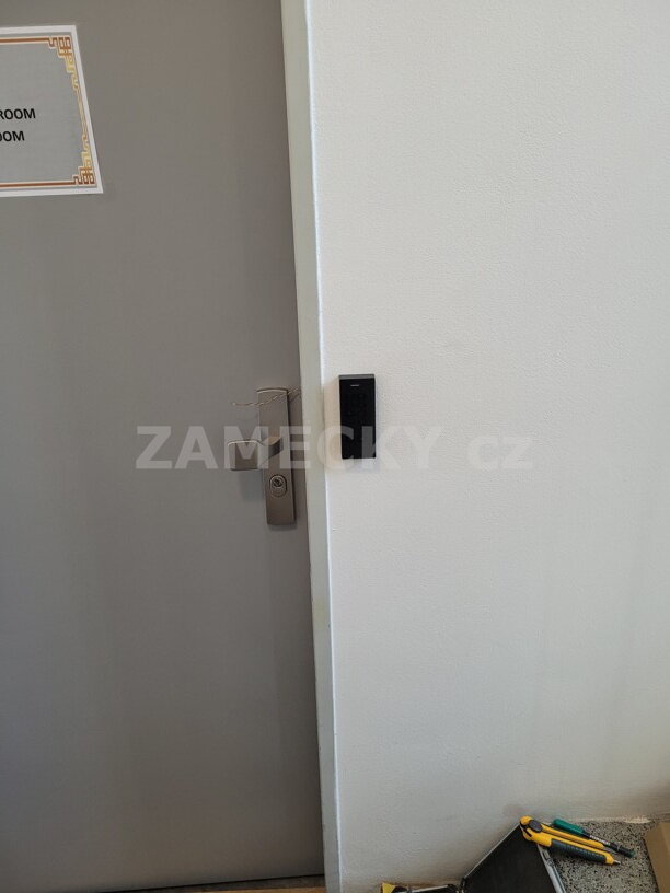 Černá přístupová čtečka AL2S s klávesnicí pro vstup na PIN kód instalovaná v ubytovně pro zaměstnance.