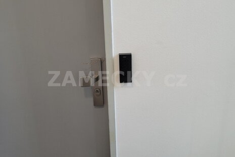 Černá přístupová čtečka AL2S s klávesnicí pro vstup na PIN kód instalovaná v ubytovně pro zaměstnance.